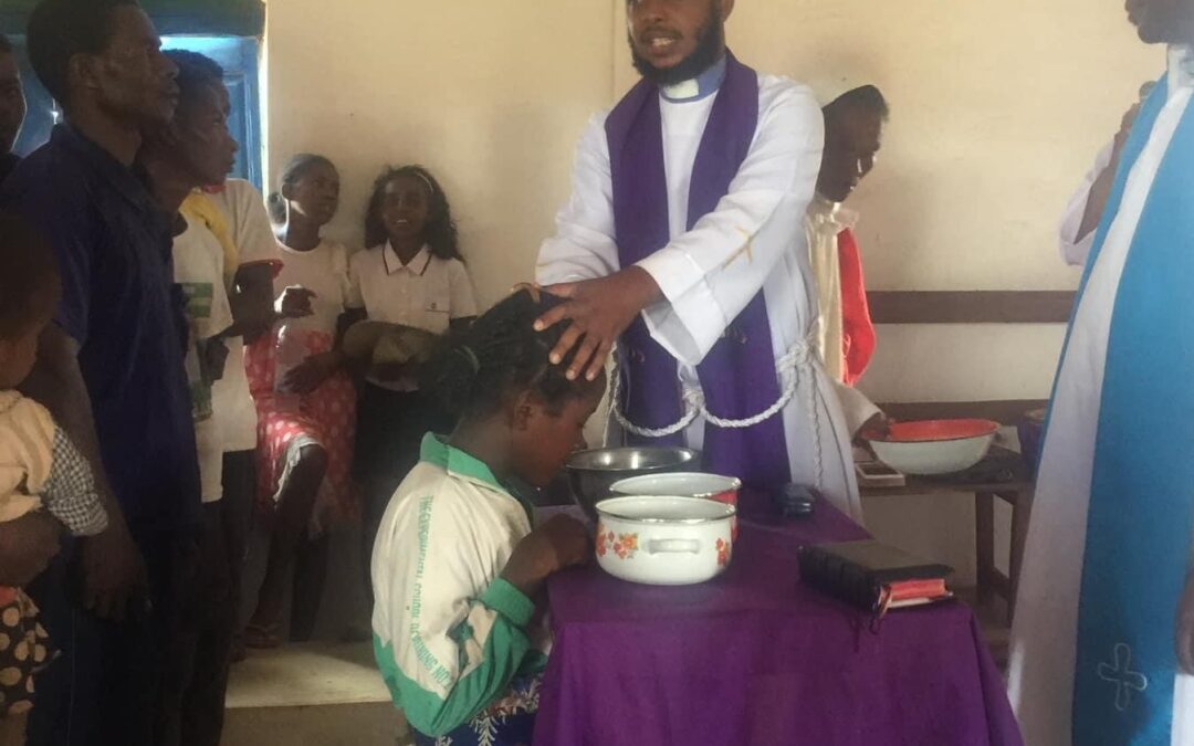 Anglican pastor blessing young girl